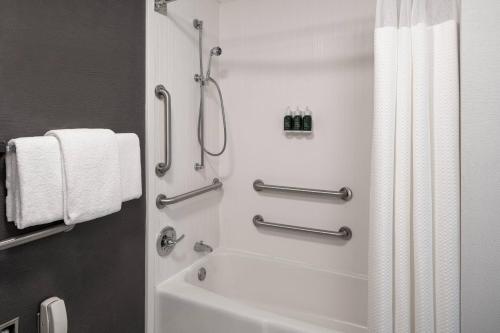 een badkamer met een douche en een wit bad bij Courtyard by Marriott Dulles Airport Herndon/Reston in Herndon