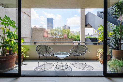 two chairs and a table on a balcony with plants at Majestic 1BR with Balcony in Cuauhtémoc in Mexico City