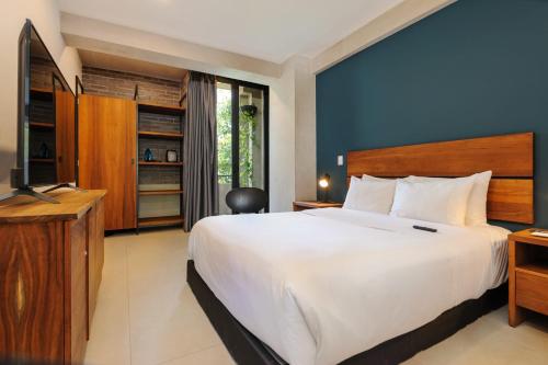 a bedroom with a large white bed and a television at Majestic 1BR with Balcony in Cuauhtémoc in Mexico City