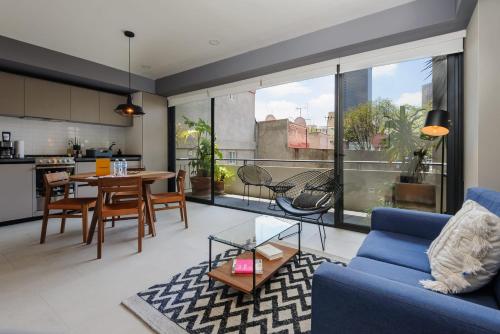 a living room with a blue couch and a table at Majestic 1BR with Balcony in Cuauhtémoc in Mexico City