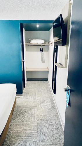 a small room with a bed and a door with a closet at Kyriad Direct Laon in Laon