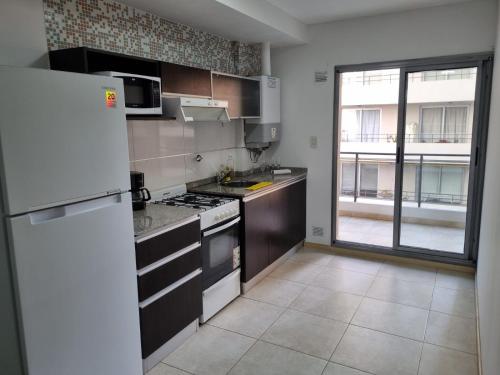 a kitchen with a white refrigerator and a large window at BELLISIMO, Amplio, a solo 100 metros del RIO, la zona VIP de Rosario!!! in Rosario