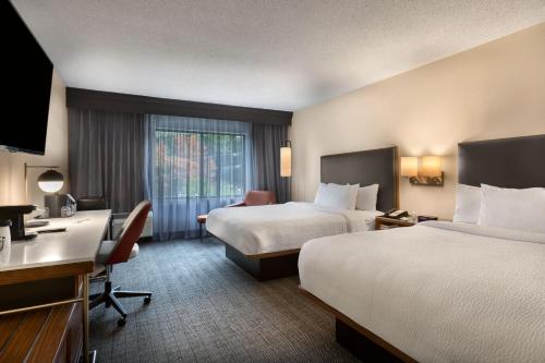 um quarto de hotel com duas camas e uma secretária em Courtyard Winston-Salem Hanes Mall em Winston-Salem