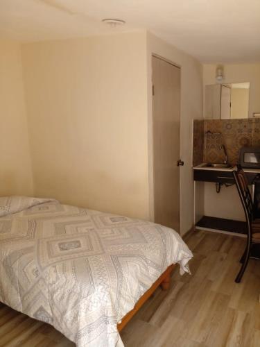 1 dormitorio con cama, mesa y escritorio en HABITACIÓN EN ZONA RESIDENCIAL CERCA DE FASHION MALL en Chihuahua