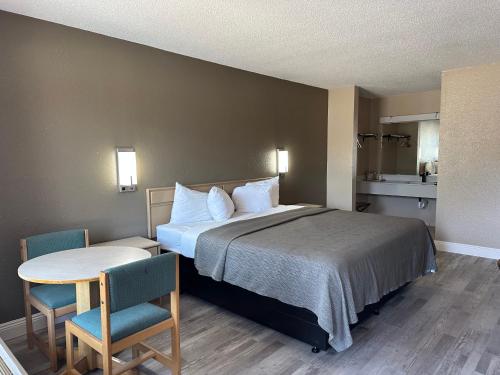 Una habitación de hotel con una cama, una mesa y sillas. en Travelers Rest Motel, en Bogalusa