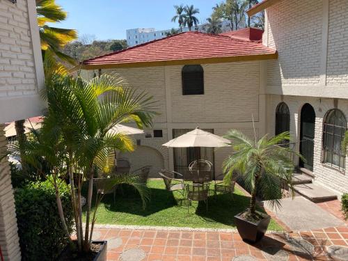 Casa con patio con mesa y sombrilla en Hotel Ilebal en Cuernavaca