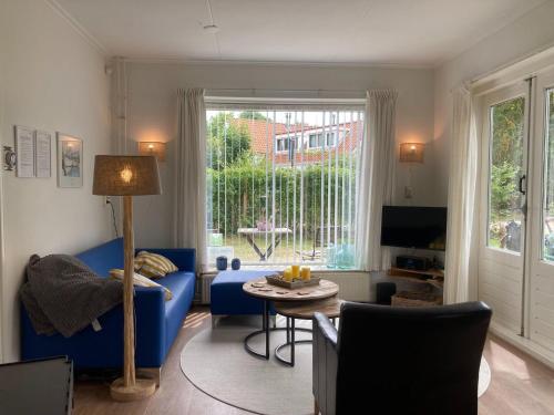 - un salon avec un canapé bleu, une table et une fenêtre dans l'établissement Cozy Holiday home in Koudekerke Zealand, à Dishoek