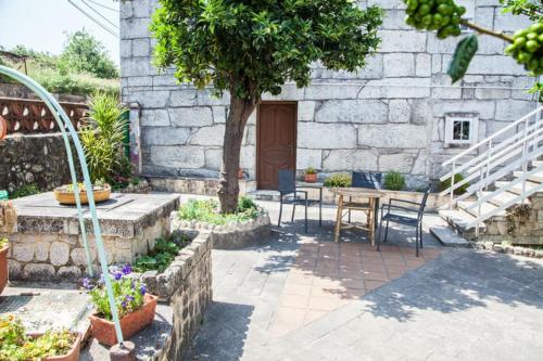 eine Terrasse mit einem Tisch und Stühlen sowie ein Gebäude in der Unterkunft Casa Donas in Gondomar