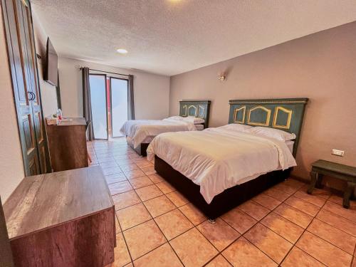 Cette chambre comprend 2 lits et une table. dans l'établissement Hotel Casa Real Cholula, à Cholula
