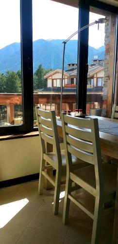 2 chaises blanches assises à côté d'une table et d'une fenêtre dans l'établissement ALL VIEW in Golf Resort, à Razlog