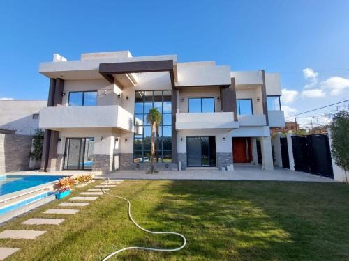 una casa grande con piscina frente a ella en Villa Bakr, en Alejandría