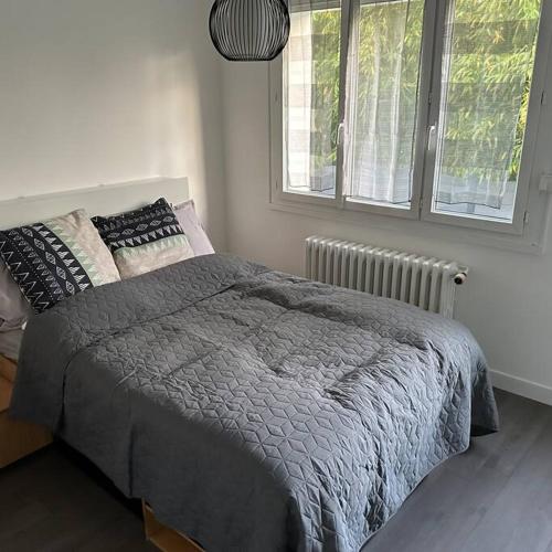 een slaapkamer met een bed en 2 ramen bij A home away from home in Rennes