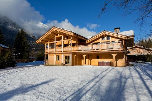 シャモニー・モンブランにあるChalet Isabelle Mountain lodge 5 star 5 bedroom en suite sauna jacuzziの庭付きの雪の中のログキャビン