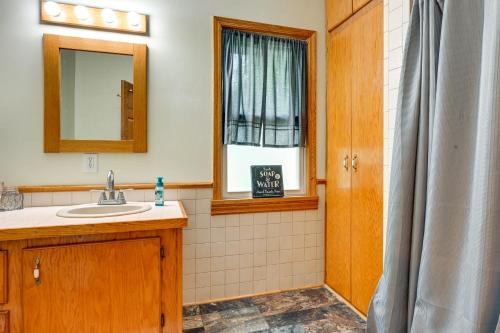 łazienka z umywalką, lustrem i oknem w obiekcie Grand Blanc Rental with Gas Grill and Private Yard w mieście Grand Blanc