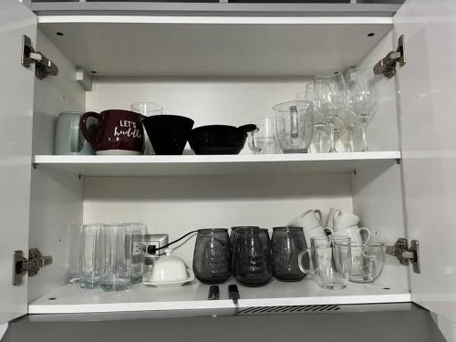 a shelf with glasses and other items on it at Encanto Cayala, Acogedor y Moderno apartamento en Cayala con Aire Acondicionado in Guatemala