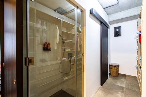 La salle de bains est pourvue d'une douche avec une porte en verre. dans l'établissement Encanto Cayala, Apartamento moderno a minutos caminando de Embajada USA y Paseo Cayala, à Guatemala