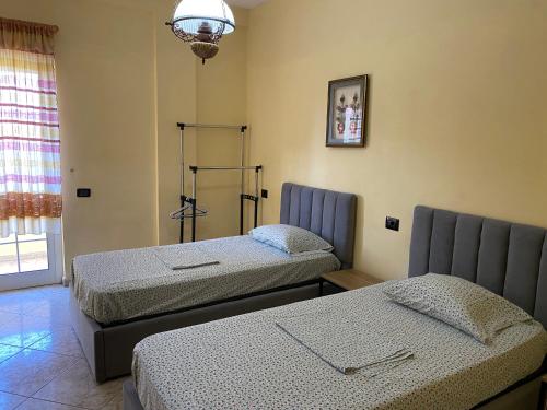 um quarto com duas camas num quarto com uma janela em Tirana Apartment white em Tirana