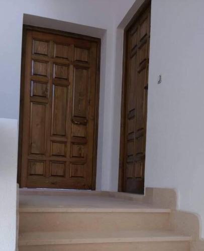 two wooden doors in a room with a staircase at Résidence le corail de chat meriem in Sousse