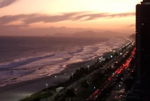 a view of a busy beach with traffic at sunset at Wyndham Rio Barra in Rio de Janeiro