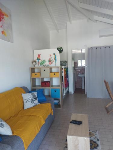 una sala de estar con un sofá y una mesa en Studio Ti Coco, en Sainte-Anne