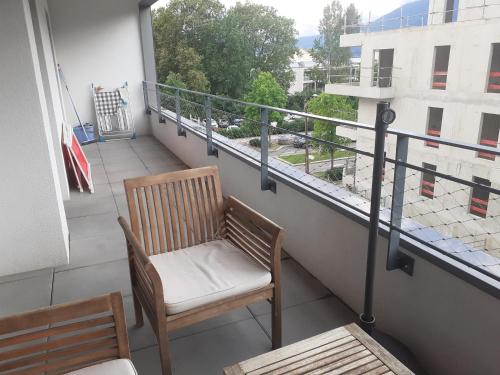 einen Balkon mit einem Stuhl und Blick auf ein Gebäude in der Unterkunft Les Picaillons - A 200m du lac in Aix-les-Bains