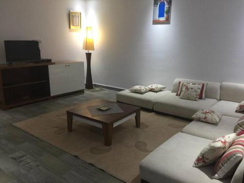 - un salon avec un canapé et une table basse dans l'établissement Résidence le corail de chat meriem, à Sousse