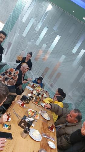 Un gruppo di persone seduti intorno a un tavolo che mangiano cibo di Ultra lüks eşyalı kiralık daire a Of