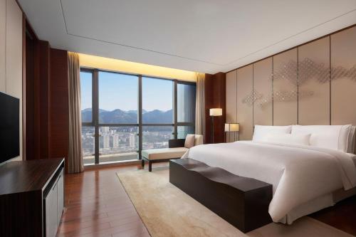 um quarto com uma cama grande e uma janela grande em The Westin Chongqing Liberation Square em Chongqing