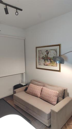 a living room with a couch and a painting on the wall at Luminoso Estudio en Palermo! II in Buenos Aires