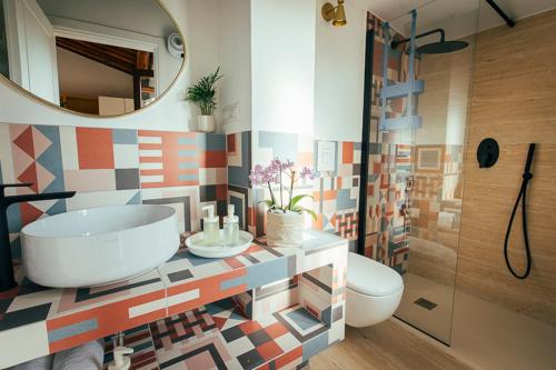 ein Badezimmer mit einer Badewanne, einem WC und einem Spiegel in der Unterkunft Studio50 in Tivoli