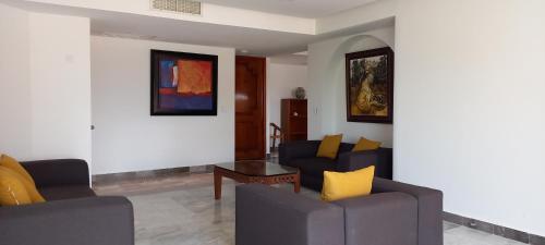 a living room with two couches and a table at Hotel & Museo Casa Turquesa in Cancún