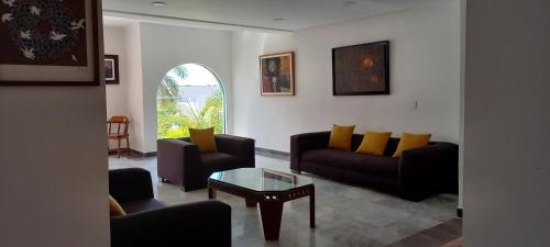 a living room with couches and a coffee table at Hotel & Museo Casa Turquesa in Cancún