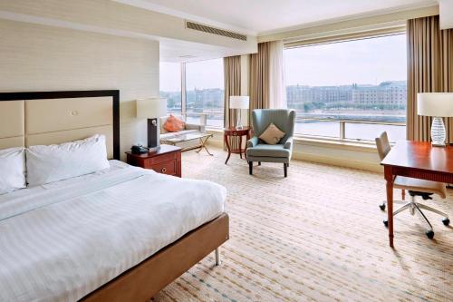 Großes Hotelzimmer mit einem Bett, einem Schreibtisch und einem Schreibtisch. in der Unterkunft Copenhagen Marriott Hotel in Kopenhagen