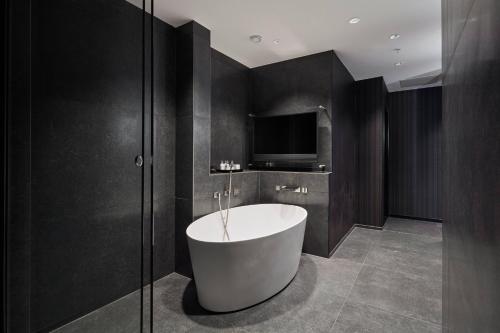 a bathroom with a bath tub and a tv at Copenhagen Marriott Hotel in Copenhagen