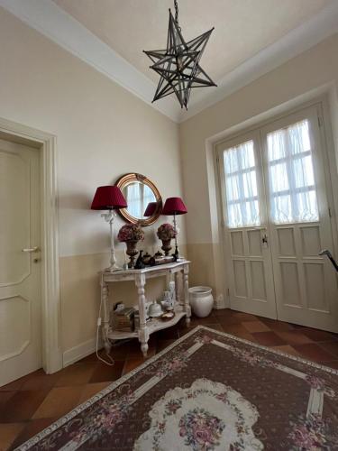 een kamer met een tafel met twee lampen en een spiegel bij Guesthouse DaVinci in Lamporecchio