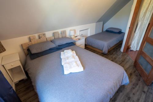 a bedroom with two beds with towels on them at Gîte B&B - Aubergélit inc in Saint-Jean-Port-Joli