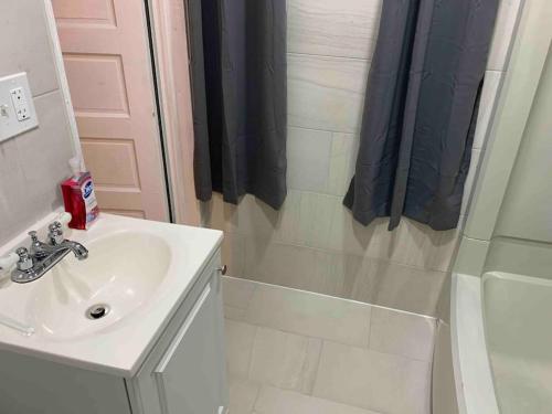a white bathroom with a sink and a shower at Apartment in Daytona Beach 1BR 1Bath Centrally Located in Daytona Beach