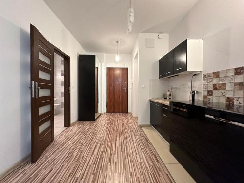 a kitchen with a wooden floor and a door at Two rooms apartment Triton Park in Warsaw