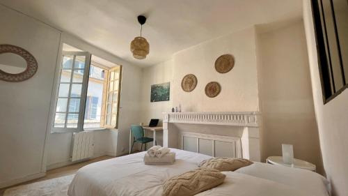 une chambre blanche avec un lit et un bureau dans l'établissement Le cocon de la cathédrale, à Nevers