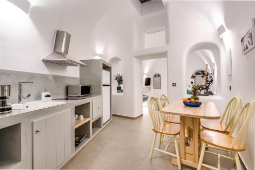 a kitchen and dining room with a table and chairs at Tiara Suites Santorini in Fira