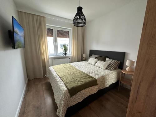 een kleine slaapkamer met een bed en een raam bij Apartament 28 w Dolinie Baryczy - 5D Apartamenty in Milicz