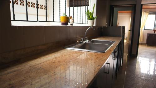 a kitchen with a sink and a wooden counter top at Hostal Casa Amatista in Pereira