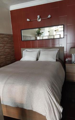 a bedroom with a large bed with a red wall at Central Praia Beach House in Praia da Vitória