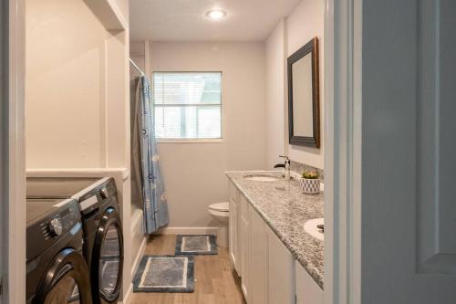 a bathroom with a sink and a washing machine at Clark House Perfect for Workers! in Orange