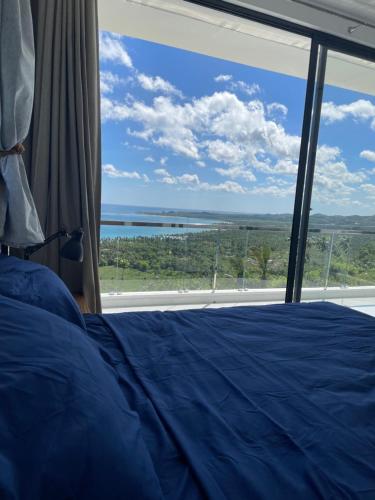 a bedroom with a bed and a large window at Villa Ocean Blue in Las Terrenas