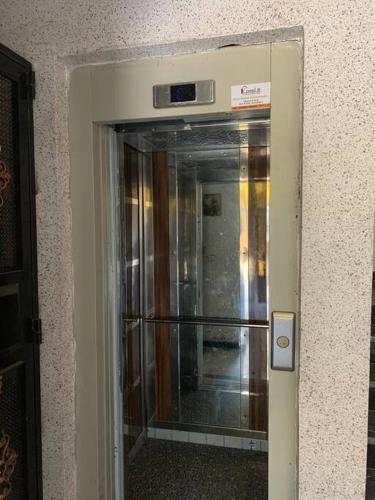 une porte en verre menant à un ascenseur dans un immeuble dans l'établissement Bienvenue chez Walid, à Larache