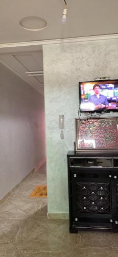 TV de pantalla plana en la pared de una habitación en Bienvenue chez Walid en Larache