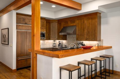 a kitchen with wooden cabinets and a counter with stools at The Porches in Steamboat Springs