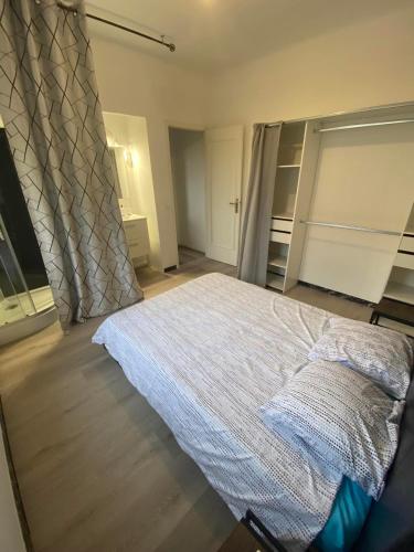 une chambre avec un lit blanc et une fenêtre dans l'établissement Les studios des mandariniers, à Cagnes-sur-Mer