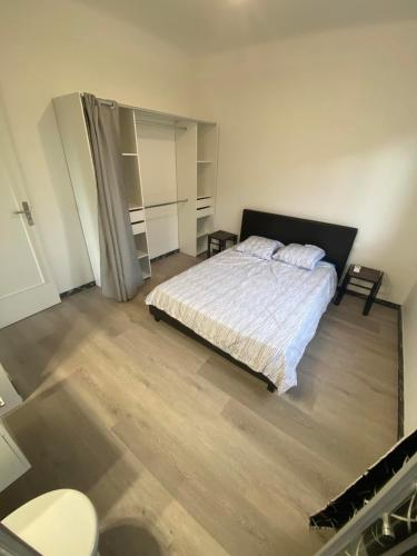 une chambre avec un lit et un parquet dans l'établissement Les studios des mandariniers, à Cagnes-sur-Mer